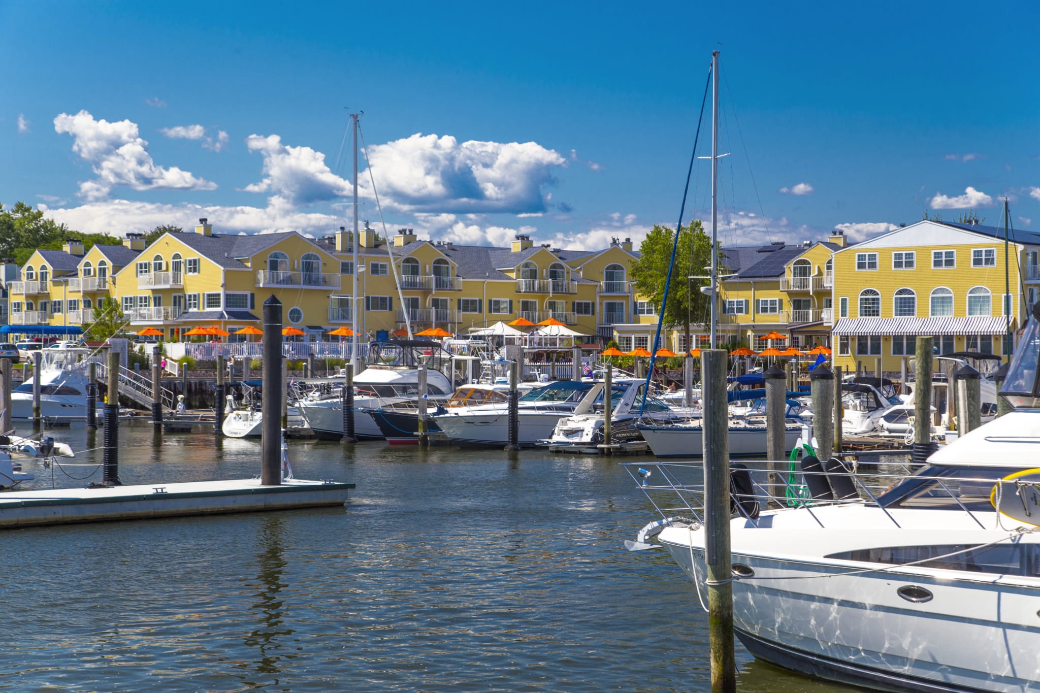 Boats in a marina in front of Saybrook Point Resort & Marina on a sunny day.