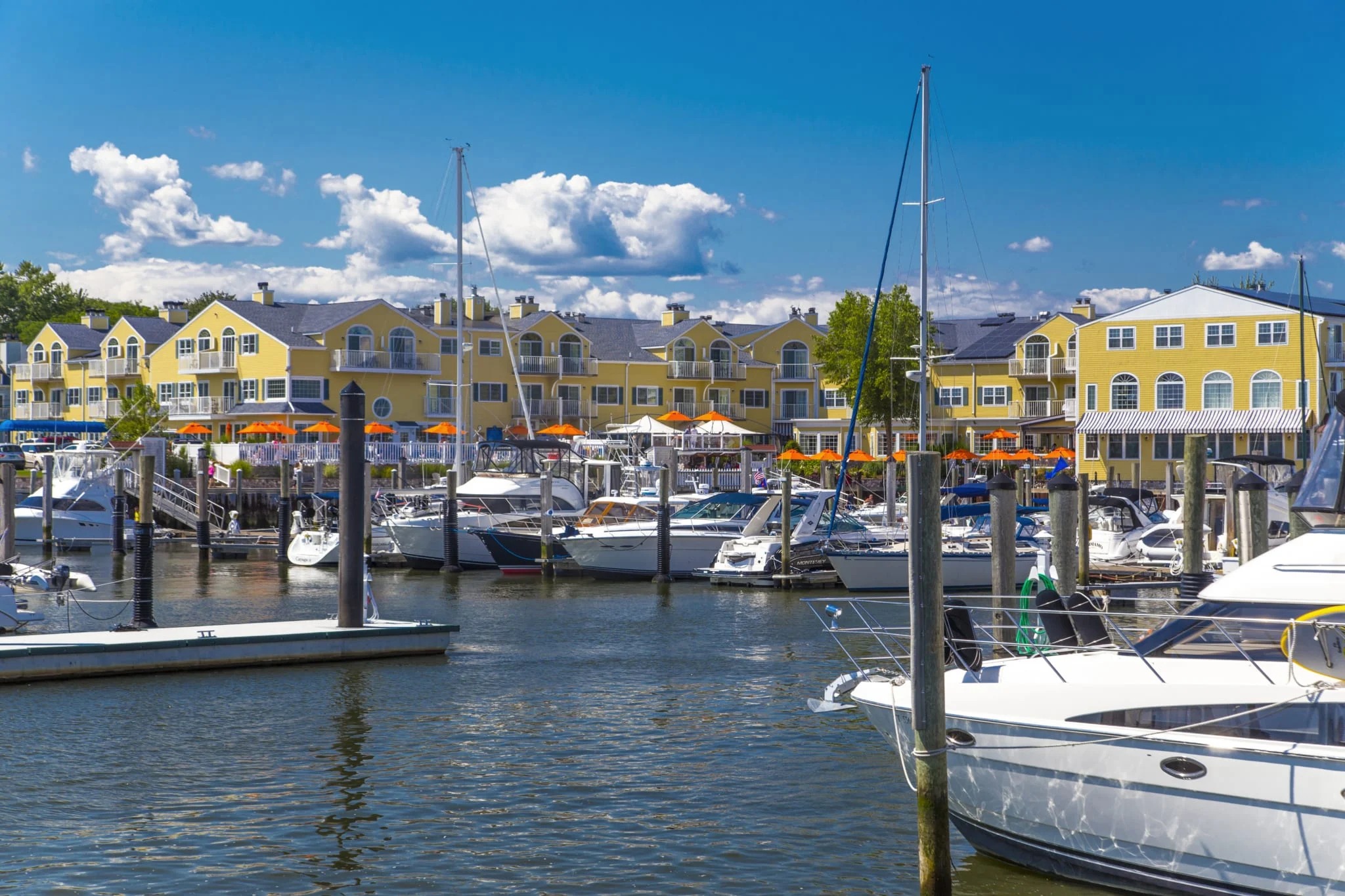 Boats in a marina in front of Saybrook Point Resort & Marina on a sunny day.