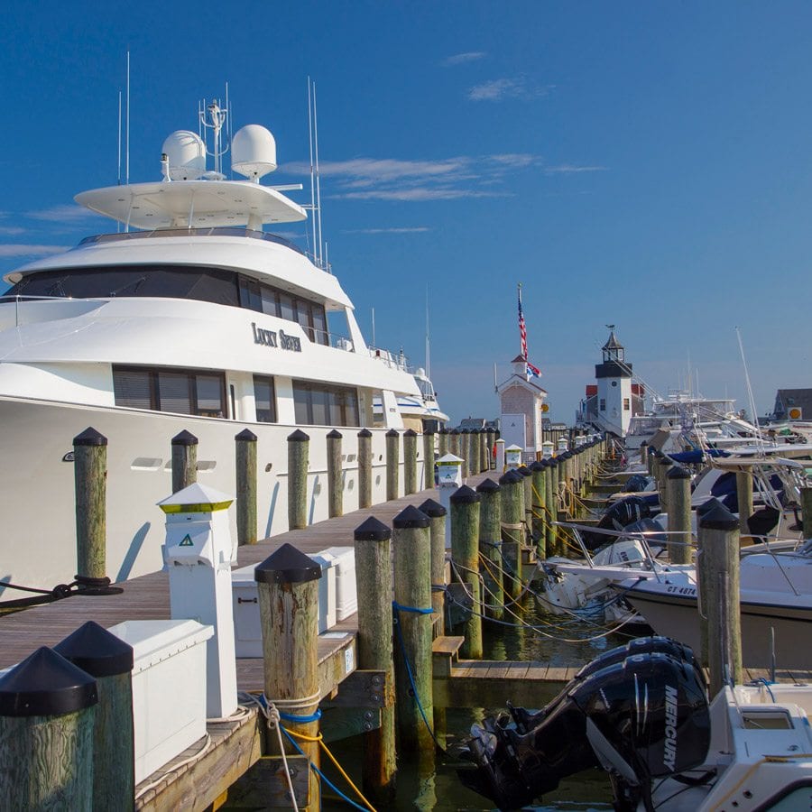 Yacht parked in Saybrook Point Resort & Marina marina with smaller boats parked on the other side of the dock.