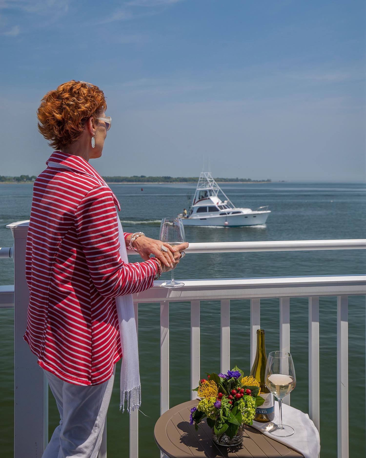 OIder Red Haired Women On Balcony Looking At Boats On The Connecticut River