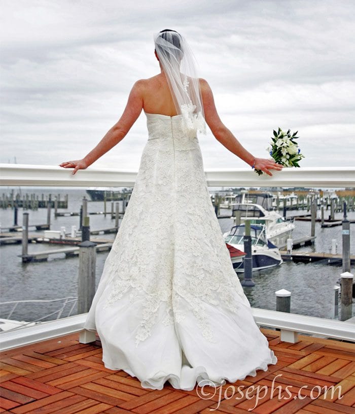 Bride looking out on harbor.