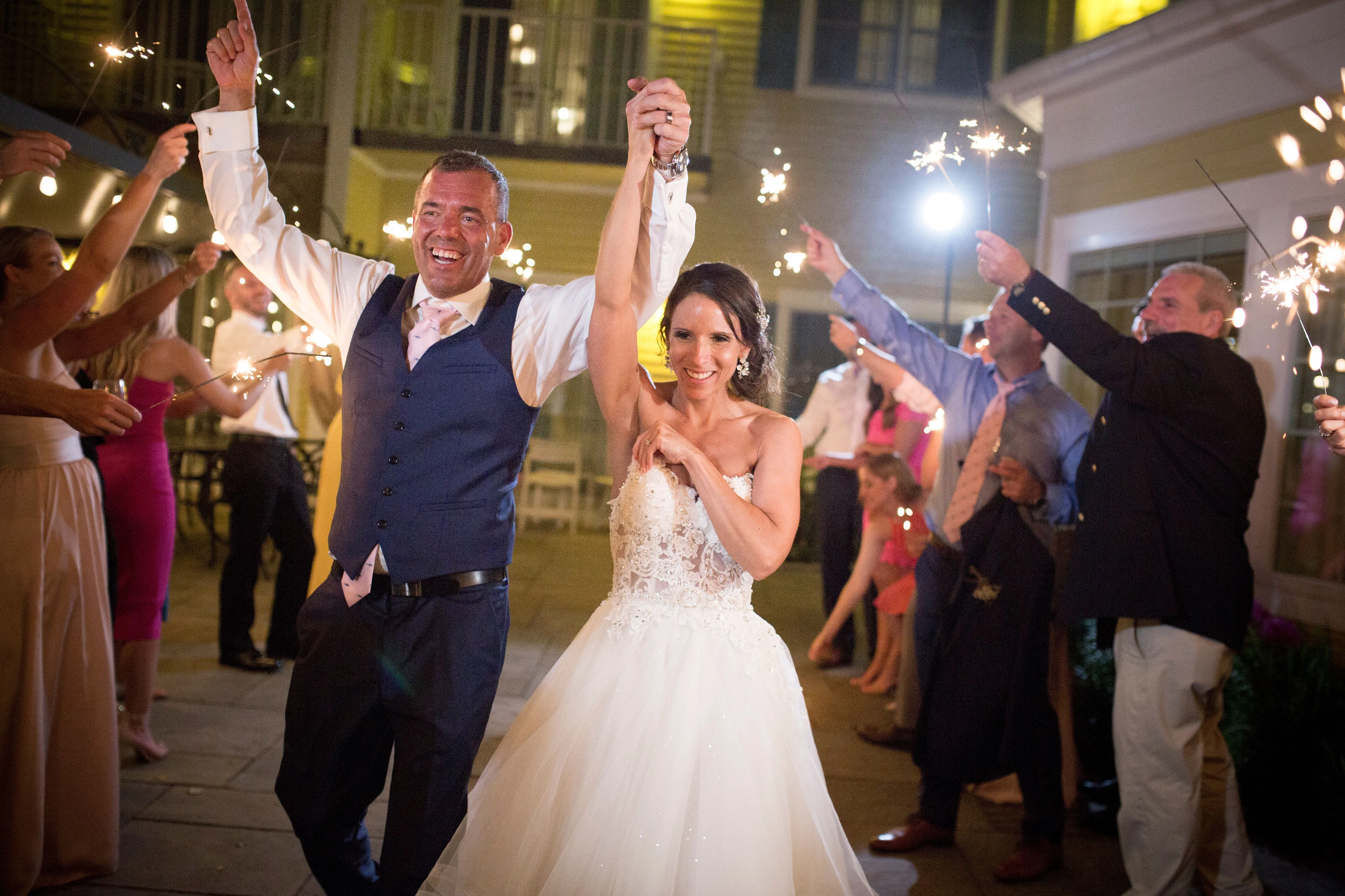 Jessica and Mike walking past guests with sparklers